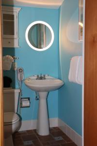 
a bathroom with a sink, toilet and mirror at La Te Da - Adult Only, 21 or older in Key West
