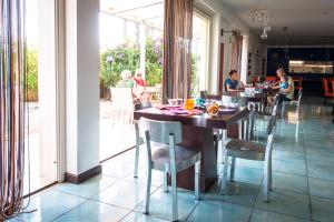 eine Gruppe von Menschen, die an einem Tisch in einem Restaurant sitzen in der Unterkunft La Locanda Del Mare in Paestum