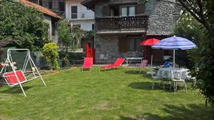 a yard with chairs and a table and an umbrella at Casa Vacanze Anilla&Miotto in Montjovet