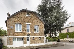 une maison en briques avec un garage blanc dans l'établissement Corneille by Cocoonr, à Rennes