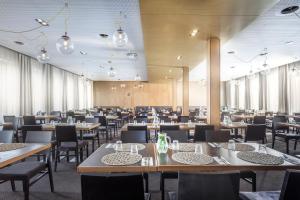ein großes Esszimmer mit Tischen und Stühlen in der Unterkunft Hotel Golf Depandance in Prag