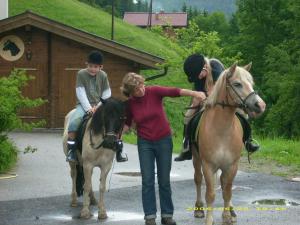 a woman is standing next to a boy on a horse at Hacklgut in Radstadt