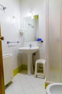 een badkamer met een wastafel, een spiegel en een kruk bij Hostel Carvalho in Mondim de Basto