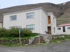 a house on the side of a road with a mountain at Stekkar 23 in Patreksfjörður