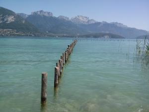 a pier in the water with mountains in the background at Centre Jean XXIII in Annecy