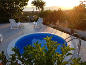 a pool with two chairs and a table with a view at La Mariposa de La Reina in Ercolano