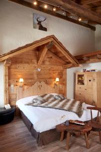 ein Schlafzimmer mit einem großen Bett in einem Holzzimmer in der Unterkunft Hotel L'Equipe in Morzine