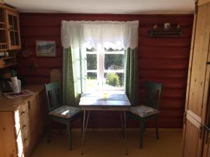 ein Tisch und Stühle in einer Küche mit Fenster in der Unterkunft Løngdal in Tuddal