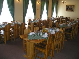 uma sala de jantar com mesas e cadeiras de madeira em Hotel U Sládka em Chodová Planá