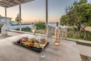 een bord eten en twee glazen wijn op een tafel bij Mandrakia Bliss House in Mandrakia