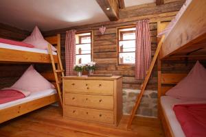 1 Schlafzimmer mit 2 Etagenbetten in einem Blockhaus in der Unterkunft Hütte Almrausch in Oberstdorf