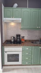 a kitchen with green cabinets and a stove top oven at VV Paraíso Del Sur in Playa Paraiso