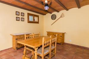 ein Esszimmer mit einem Holztisch und einer Uhr an der Wand in der Unterkunft Casa Las Eras in Beceite