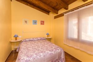 1 Schlafzimmer mit einem Bett, einem Fenster und 2 Tischen in der Unterkunft Casa Las Eras in Beceite