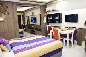 バンコクにあるFamily Suite Room Pratunamのベッドルーム1室(ベッド1台、テーブル、椅子付)