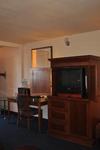 Habitación de hotel con TV y escritorio con mesa. en Budget Inn, en San Luis Obispo