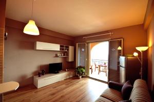 un soggiorno con divano e TV e una cucina di Casa Antonella a Letoianni