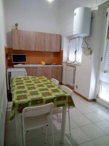 a kitchen with a table and chairs in a room at Appartamenti Dalì in Bernalda