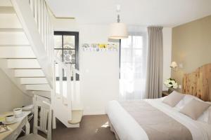 a bedroom with a white bed and a staircase at Hôtel Restaurant Corto Maltese in Le Palais
