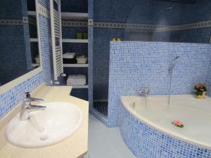 baño de azulejos azules con lavabo y bañera en Villa Nieves, en Ibiza 15 fotos más