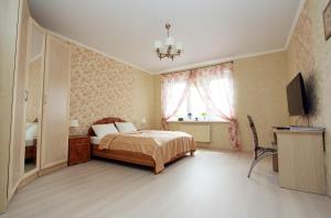 a bedroom with a bed and a flat screen tv at Apartment Shakhmatnaya in Kaliningrad