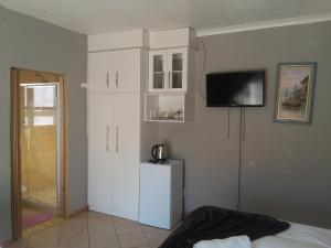 a bedroom with white cabinets and a television on the wall at Dudsk Bed & Breakfast in Newcastle