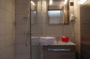 a bathroom with a shower and a sink with towels at La Clé des Champs in Lanslebourg-Mont-Cenis