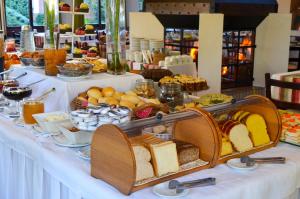 ein Buffet mit Brot und anderen Speisen auf dem Tisch in der Unterkunft Vila Suzana Parque Hotel in Canela