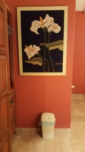 baño con aseo y una foto en la pared en Los Colorados Hostal en Angastaco