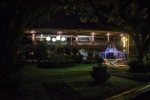 a house with lights on the front of it at night at Hotel Suerre in Guápiles