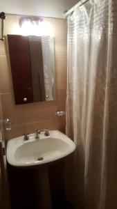 a bathroom with a sink and a shower curtain at Los Colorados Hostal in Angastaco