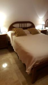 a bedroom with a large bed with two tables and two lamps at Los Colorados Hostal in Angastaco
