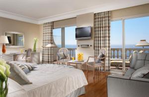 una camera con un grande letto e un soggiorno di Royal Hotel Sanremo a Sanremo