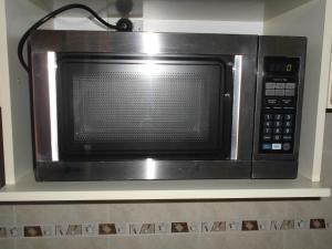 a microwave oven sitting on a shelf in a kitchen at Departamento Villa Gesell Norte sobre Playa y 310 Vista al Mar in Villa Gesell