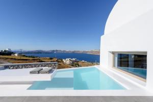 a swimming pool with a view of the water from a house at Earino Suites and Villa in Akrotiri