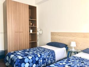 1 dormitorio con 2 camas con sábanas azules y blancas en Isola 92100 en Agrigento