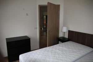 ein Schlafzimmer mit einem Bett, einer Kommode und einer Tür in der Unterkunft Kjarnagerdi Cottages in Laugar