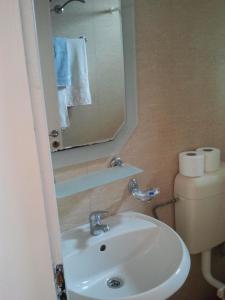 a bathroom with a sink and a mirror and a toilet at Guest House Paskal in Sunny Beach