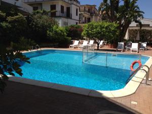 a large swimming pool with chairs and a swimming pool at Villa Nettuno Residence in Giardini Naxos