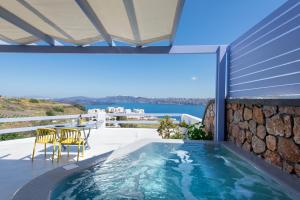 - une piscine sur une terrasse avec une table et des chaises dans l'établissement Earino Suites and Villa, à Akrotiri