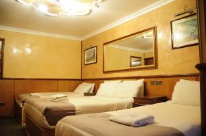 a hotel room with two beds and two lamps at Cricklewood Lodge Hotel in London
