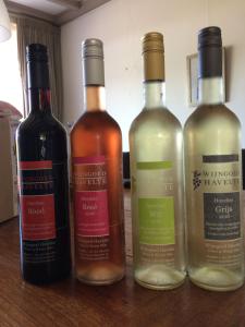 four bottles of wine sitting on a wooden table at B&B op Wijngoed Havelte in Havelte