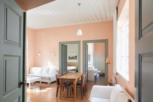 a living room with a table and a couch at Guesthouse Lila in Ermoupoli