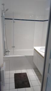 a white bathroom with a tub and a sink at lille grand boulevard in Marcq-en-Baroeul