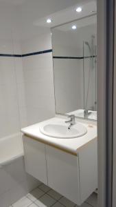 a white bathroom with a sink and a mirror at lille grand boulevard in Marcq-en-Baroeul
