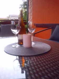 einen Tisch mit zwei Gläsern und einer Flasche Wein in der Unterkunft Apartment Pavlešić in Slunj