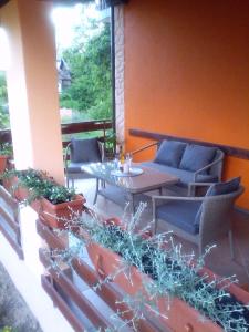 eine Terrasse mit einem Tisch und Stühlen auf einer Veranda in der Unterkunft Apartment Pavlešić in Slunj