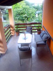 uma varanda com cadeiras e uma mesa e uma mesa e cadeiras em Apartment Pavlešić em Slunj