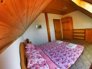 a bedroom with a bed in a room with wooden ceilings at Balaton White House in Vonyarcvashegy