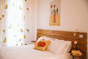 a bedroom with a white bed with a wooden headboard at Agriturismo Villa Venti in Roncofreddo